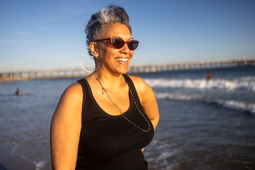 A beautiful mature black woman with a colorful skirt enjoying the California Coast.