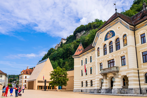 Tourists visiting the Peter-Kaiser-Platz square, the government district of Vaduz, the capital of Liechtenstein. It is home to the parliament building, the government offices and the state archives.