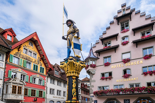Historic buildings overlooking Kolinplatz in the downtown of Zug, the capital city of the Swiss canton of Zug. In the square stands out the Kolinbrunnen, a fountain placed in 1541.