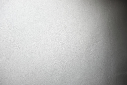 white color painted concrete wall in spot light and dark shadow on the opposite side