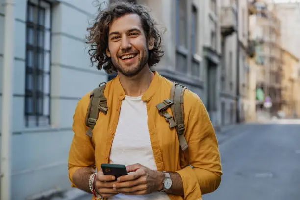 Young man walking on the street and smiling