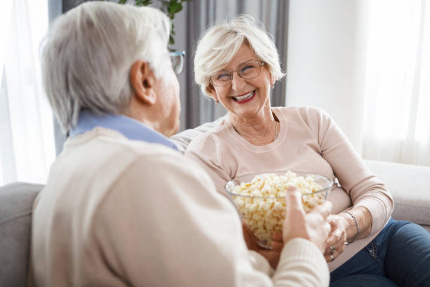 istock Mature couple relaxing at home eating popcorn 1316495030