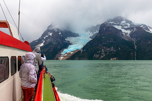 Tourists on a exploration cruise approaching the Balmaceda glacier on the Last Hope Sound, Bernardo O Higgings national park, Patagonia, Chile.