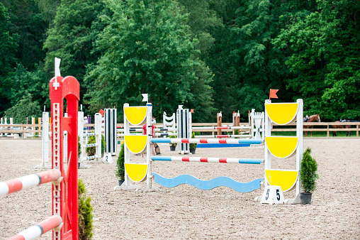 Image of show jumping poles on empty training field. Wooden barriers for horses as a background. Colorful photo of equestrian obstacles. Empty field for event competition