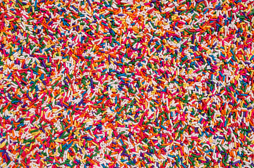 big clear display of sprinkles candy party cake treats cover food decorations background