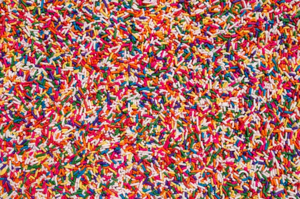 Photo of big clear display of sprinkles candy party cake treats cover food decorations background