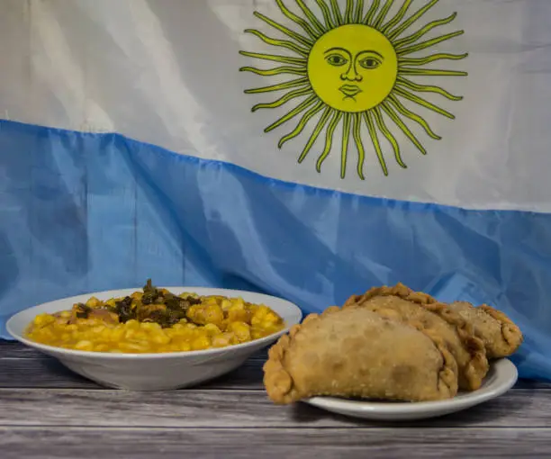 Photo of plate of locro and empanadas with the Argentine flag