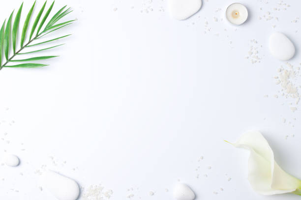 istock Spa background with white stones, candles, palm leaf and white flower on white. Flat lay,copy space 1316502870