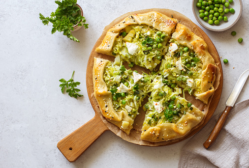 Cabbage, green peas and feta cheese open face pie(galette) close up. Flat lay