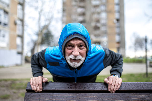 istock Sporty senior man doing push-ups on cold rainy day. 1316507595