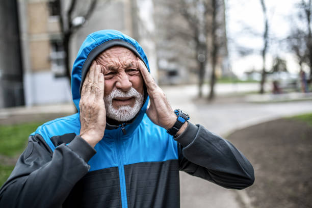 Sporty senior man having a strong headache.
