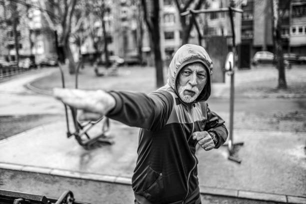 istock Sporty senior man practicing karate moves outdoors on rainy day. 1316510151