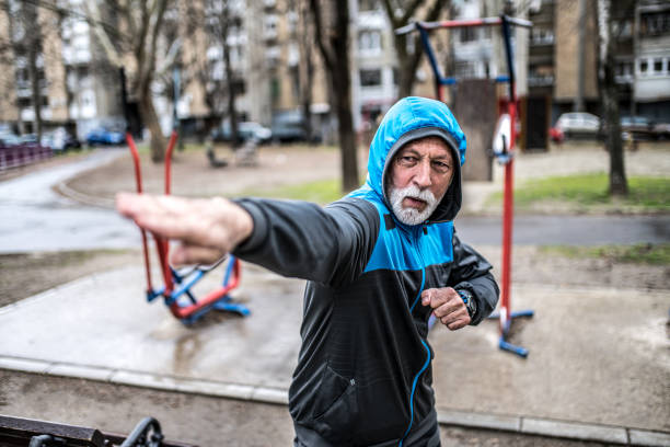 istock Sporty senior man practicing karate moves outdoors on rainy day. 1316510193