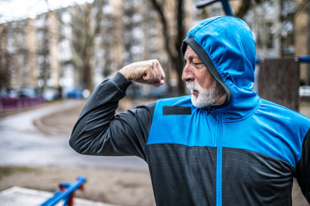 istock Sporty senior man exercising on cold rainy day and flexing muscles. 1316510213
