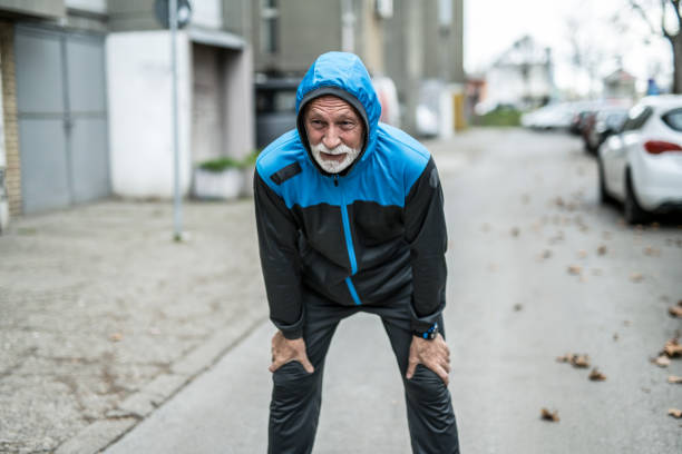 istock Tired senior man resting from running on cold rainy day. 1316512293