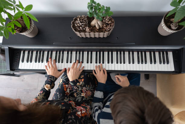 istock Mother and boy practicing piano at home 1316514373