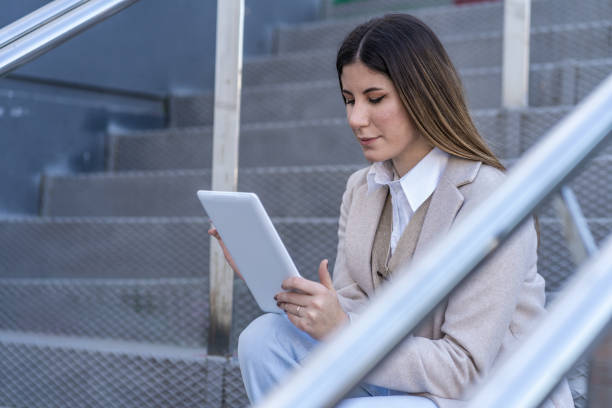 istock Caucasian woman with tablet sitting on a staircase 1316515623