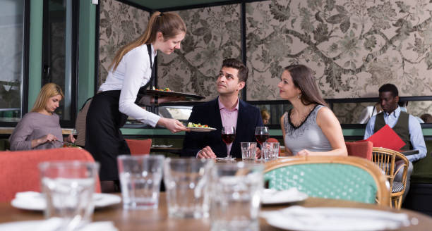istock Waitress bringing dishes to couple 1316518277