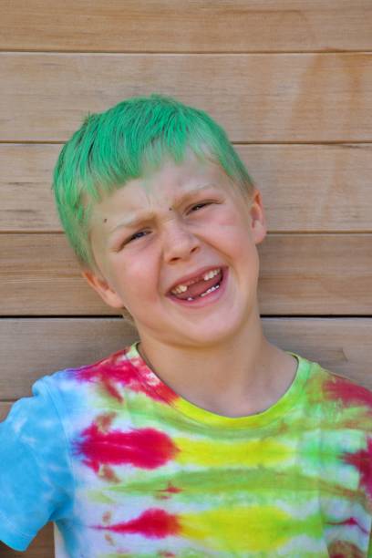 istock Child with Green Hair and Tie Dye T-Shirt Pulls a Funny Face 1316520268