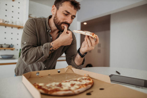 istock Man in the kitchen eating unhealthy food 1316520316