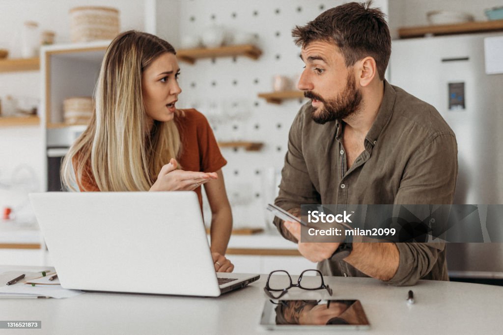 Couple in the kitchen argue Couple in the kitchen using credit card 25-29 Years Stock Photo Couple in the kitchen argue Couple in the kitchen using credit card 25-29 Years Stock Photo