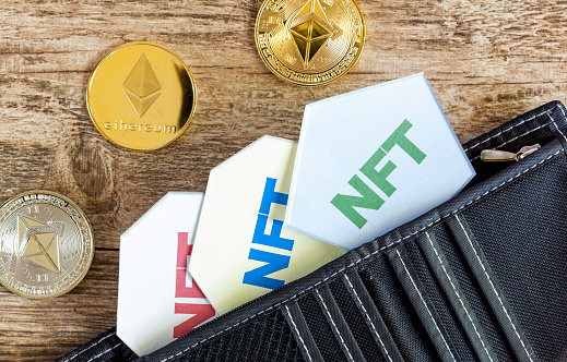 Clarksburg, MD, USA 05-01-2021: A concept image for investing in Non Fungible Tokens (NFTs) through Ethereum blockchain. These are rare digital items that are traded online. Image shows NFTs with ETH coins with a wallet.