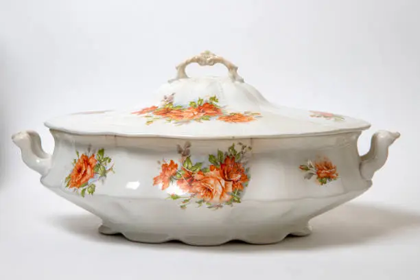 Antique porcelain tureen with flowers painted on a white background