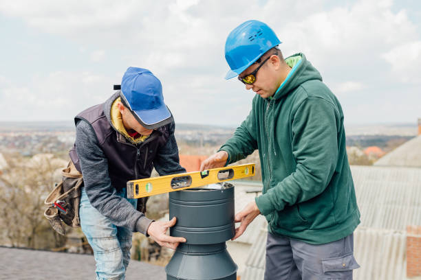 istock workers on the roof installing tin cap on the iron chimney 1316532193