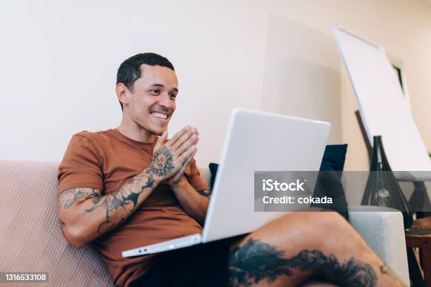 Happy Young Man Using Laptop At Home Stock Photo - Download Image Now - Domestic Life, Tattoo, Computer