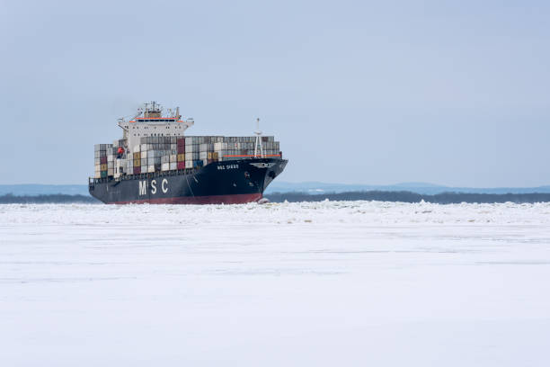 Nicolet, Quebec, Canada - 19 january 2020 : On the St. Lawrence river, a container ship crossing the iced St. Peter lake (Lac Saint-Pierre) in winter