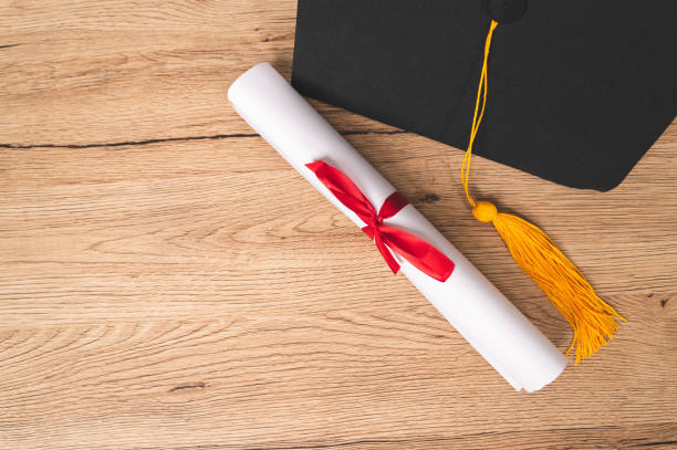 istock Graduation cap and Certificate diploma roll Paper on table in library 1316535156
