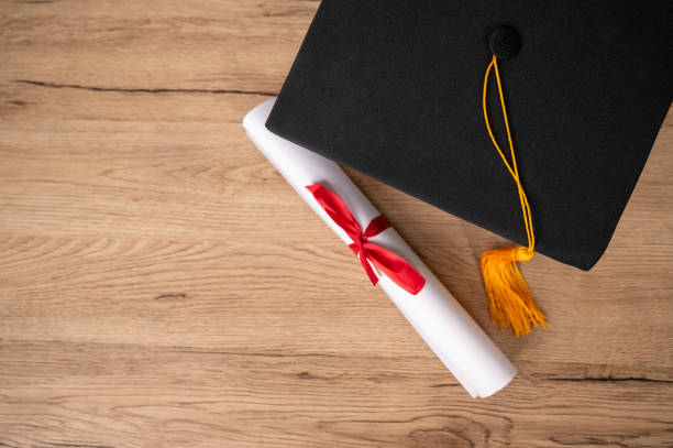 istock Graduation cap and Certificate diploma roll Paper on table in library 1316535684