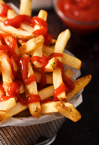 French fries with ketchup in a silver basket