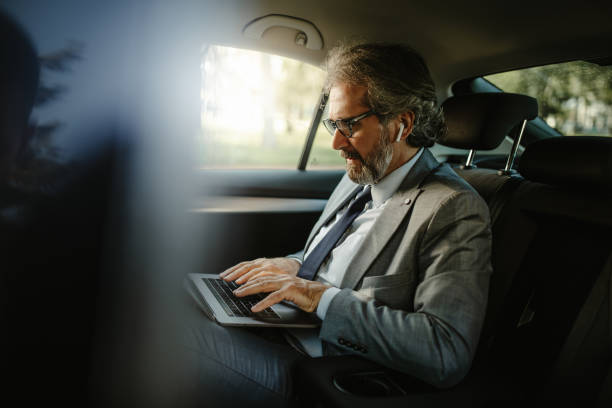 istock Always available. Handsome businessman working on his laptop while sitting in the car. 1316542133