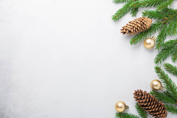 istock Minimal christmas composition. Fir tree branches with golden christmas balls and cone on stone background 1316542932