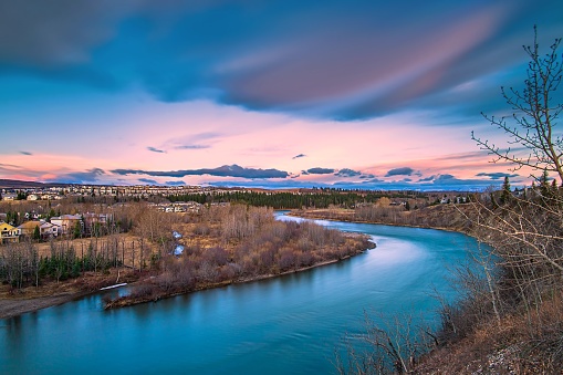 A vivid long exposure view of clouds over the Bow river from a park lookout in Cochrane.