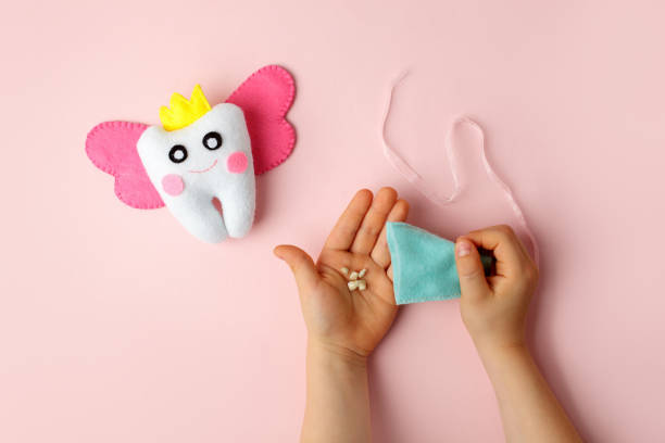 istock Felt tooth fairy pillow in kids hands on pink background with copy space for text. Handmade children's felt tooth fairy pillow. Stuffed toy crafts idea. Happy Tooth Fairy day card 1316548381