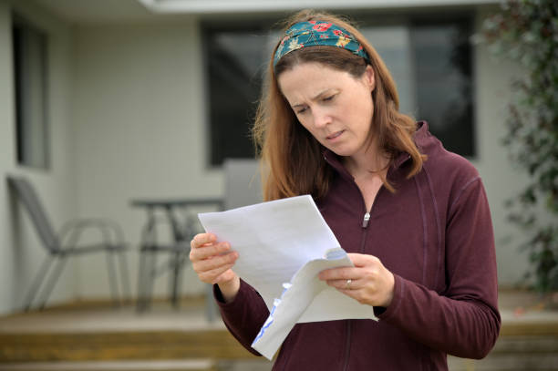 istock Woman reading a letter in home front yard 1316549386