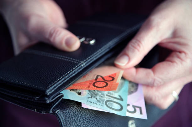 Woman hand pulling out Australian money from a wallet stock photo