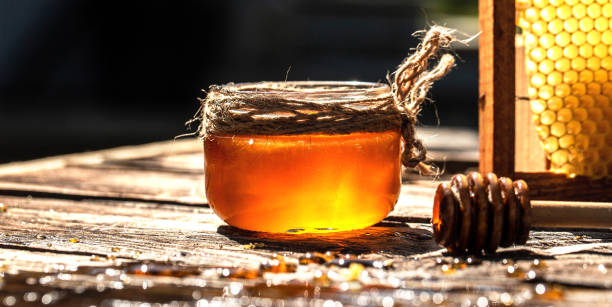 istock Honeycomb in honey Jar. reflect with sun light. Beekeeping concept. Long banner format 1316553541