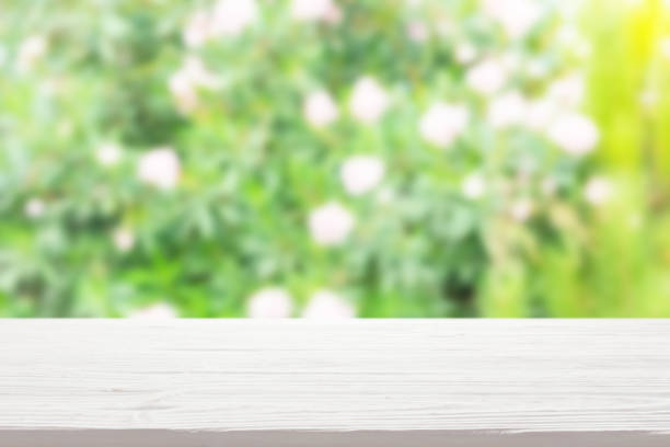 istock White wood table top on blur bush with flowers background 1316555779