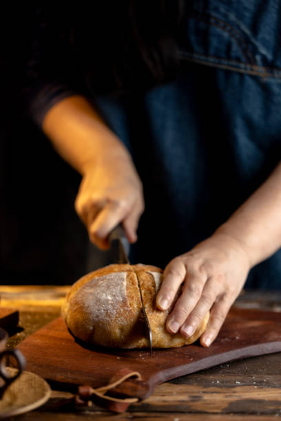 mujer cortando pan de centeno con cuchillo de pan - coffee whole wheat food bread fotografías e imágenes de stock