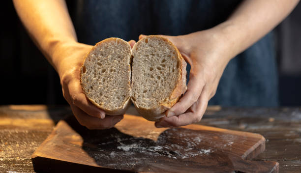 istock baker holding sourdough rye bread, checking the texture of cross section 1316556703