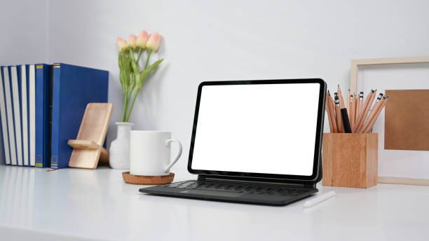 istock Neat and ordered workspace with computer tablet, coffee cup, books and office supplies on white table. 1316560260