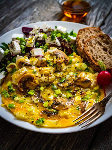 istock Continental breakfast -  scrambled eggs with mushrooms, feta cheese and fresh vegetables on wooden table 1316561385