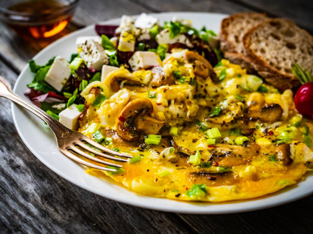 istock Continental breakfast -  scrambled eggs with mushrooms, feta cheese and fresh vegetables on wooden table 1316561390