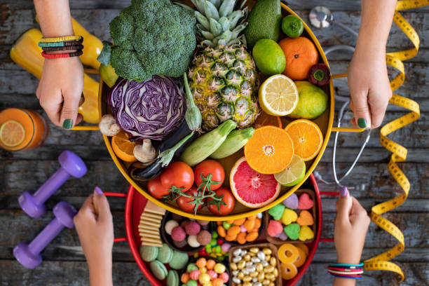 zdrowe odżywianie vs niezdrowe jedzenie z pigułki medycyny, stetoskop i taśmy mierza na stole. - nutritional supplement pill eating food zdjęcia i obrazy z banku zdjęć