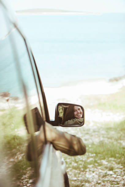 istock reflection on stunning smiling woman in car rear mirror 1316562207