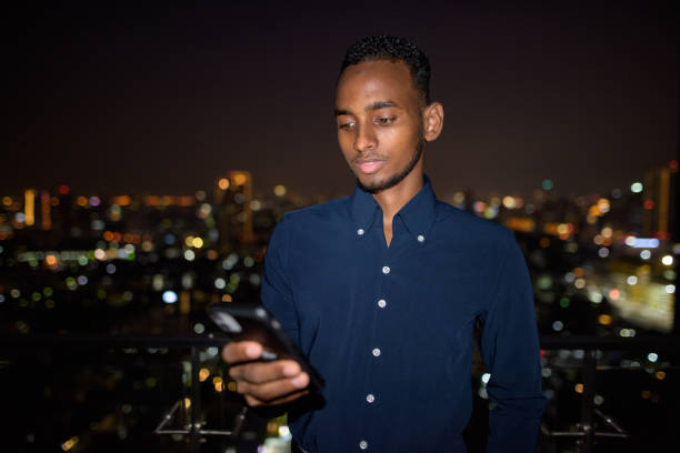 istock African businessman outdoors at rooftop using phone at night 1316563006
