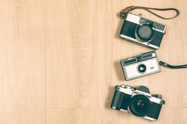 istock SLR camera, rangefinder camera and compact camera on wooden floor 1316565236